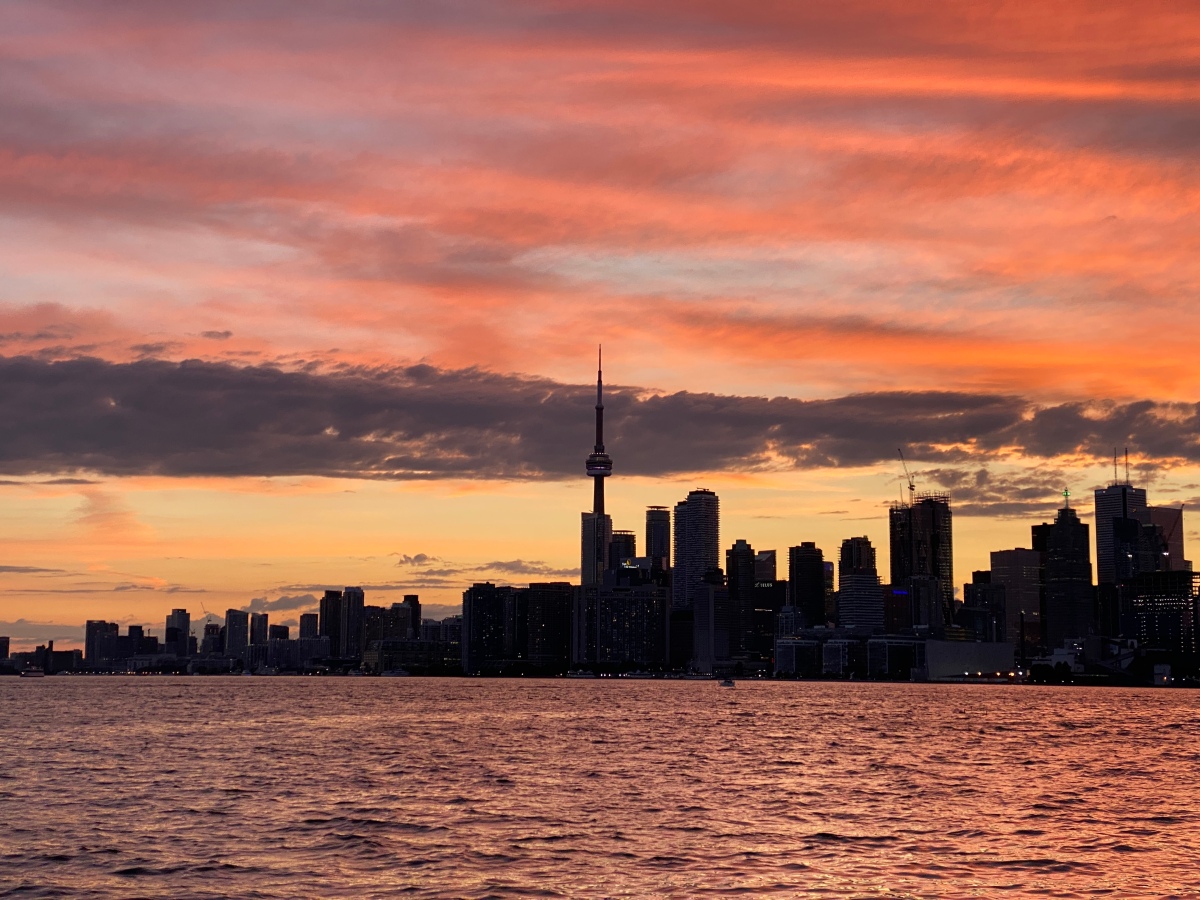 A silhouette of the Toronto skyline and a colorful sunset