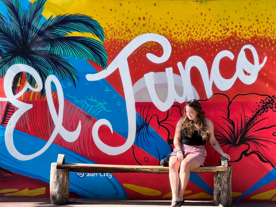 woman sitting infront of a vibrant mural